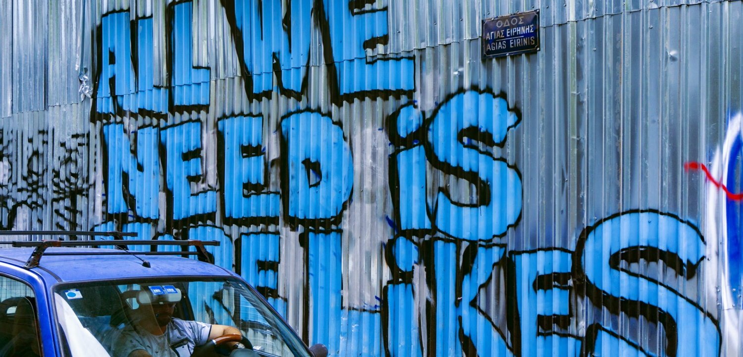 Graffiti in Facebook blue colour, saying 'All we need is more likes'